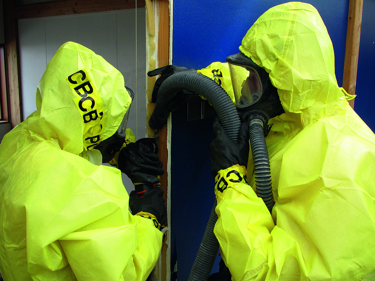 showing workers dressed in protective suits and gloves